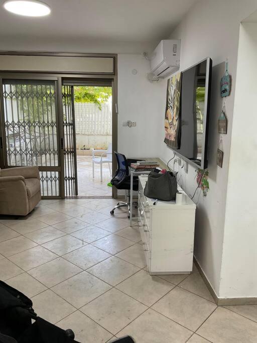 a living room with a couch and a tv on the wall at באר אשקלון in Ashkelon
