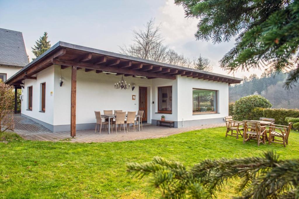 een wit huis met een tafel en stoelen bij Ferienhaus Rothaarblick in Schmallenberg