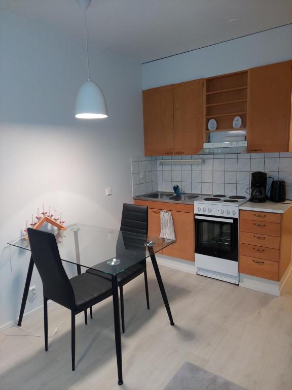 a kitchen with a table and chairs and a stove at Kauppala in Soini