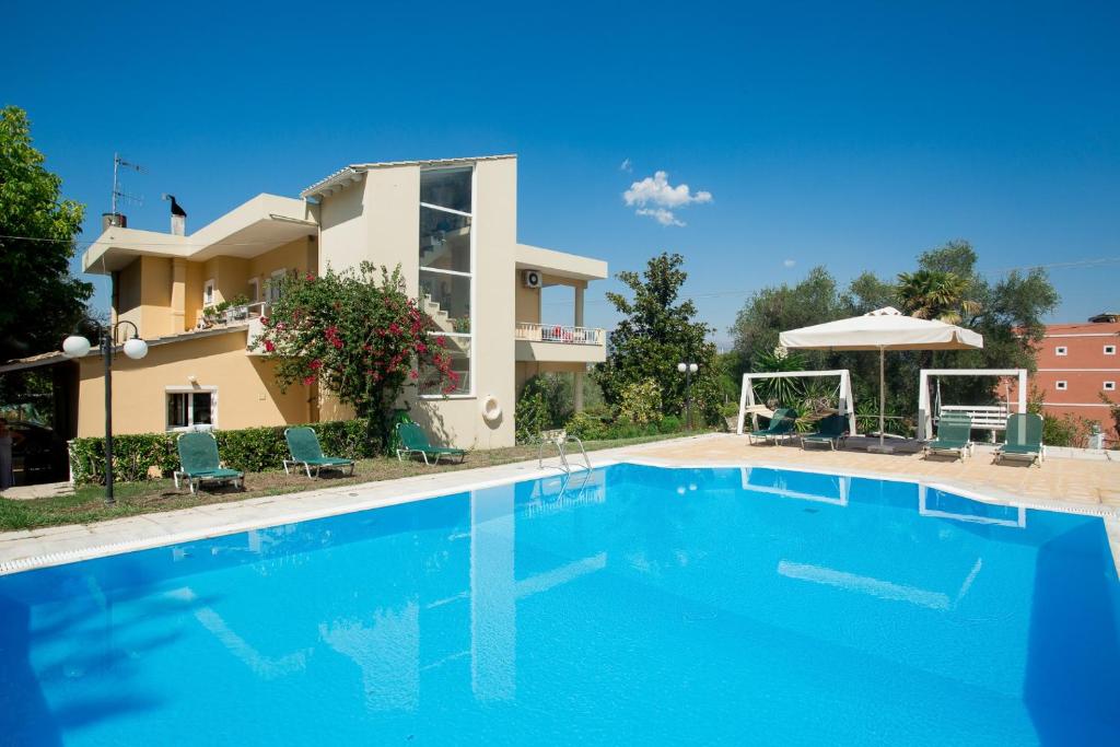 a villa with a swimming pool in front of a house at Dreamy Apartments Corfu in Kontokali