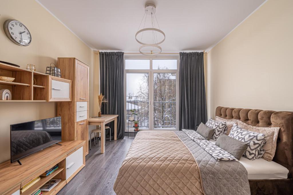 1 dormitorio con cama y ventana grande en Grizinkalns residence with free parking, en Riga