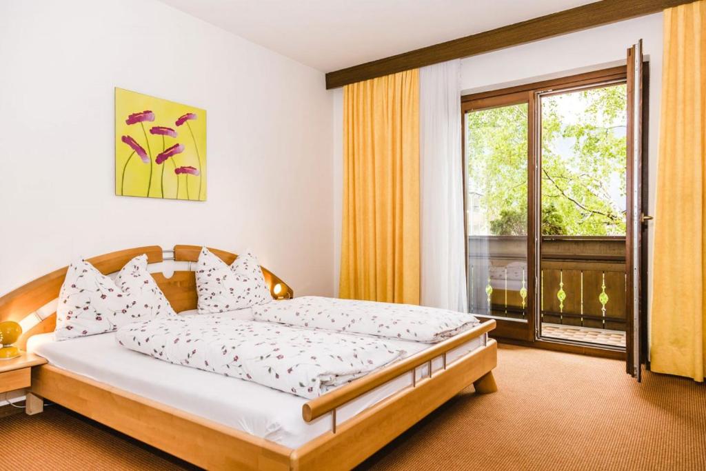 een slaapkamer met een bed en een groot raam bij Ferienwohnung Lanz 1 in Lana