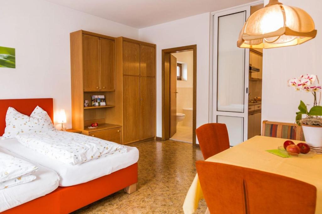 ein Hotelzimmer mit einem Bett und einem Tisch sowie einem Zimmer in der Unterkunft Ferienwohnung Lanz 3 in Lana