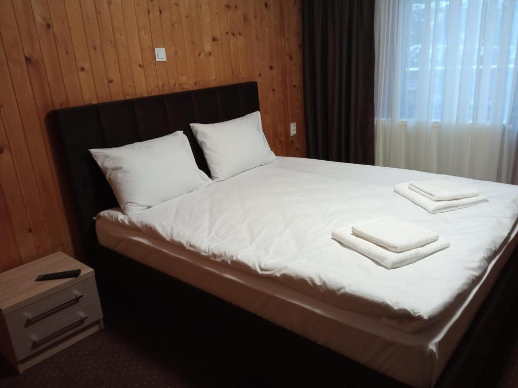 a bedroom with a bed with two towels on it at Casa Familiei in Braşov