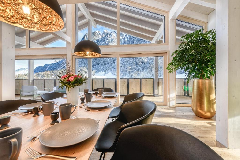 Luxus Penthouse Zentral by A-Appartments في براند: غرفة طعام مع طاولة وكراسي طويلة