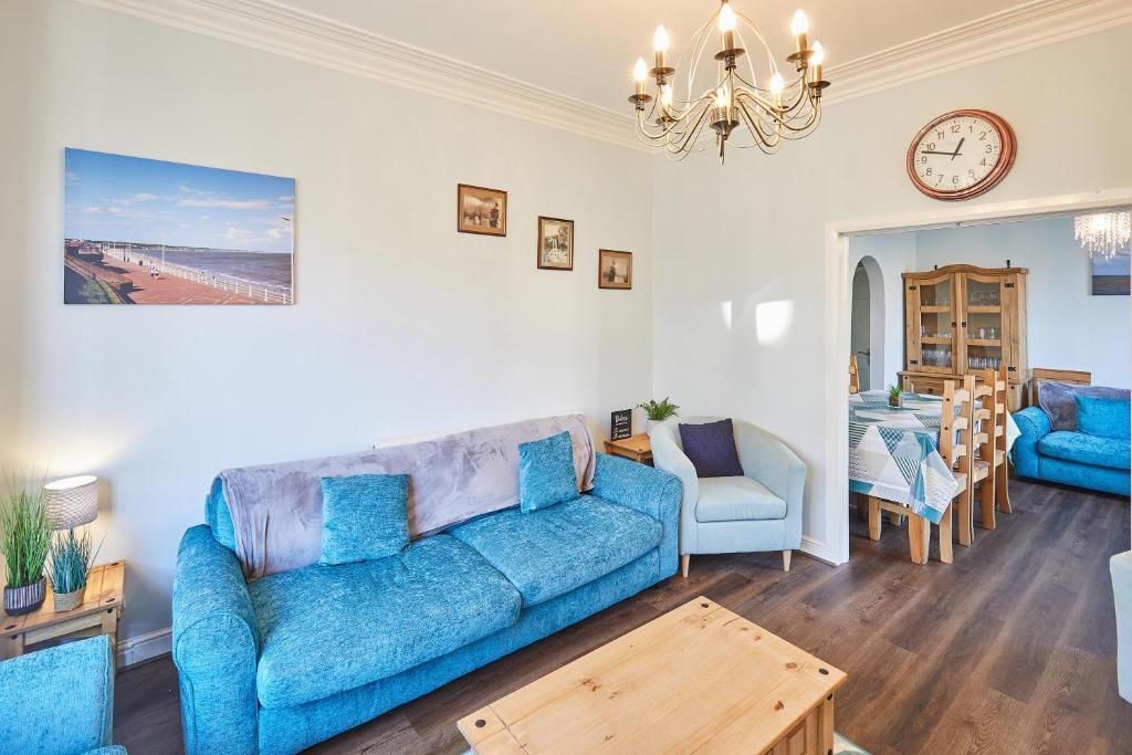 uma sala de estar com um sofá azul e uma mesa em Host & Stay - Holyrood Lodge em Bridlington