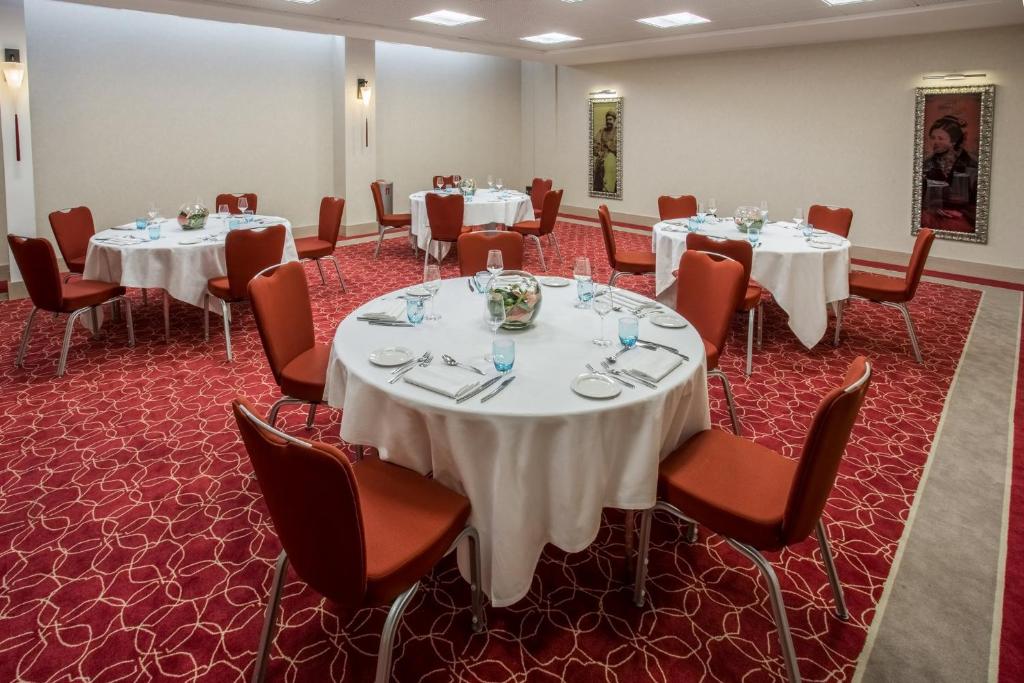 a conference room with tables and chairs with white table cloths at Crowne Plaza Montpellier Corum, an IHG Hotel in Montpellier