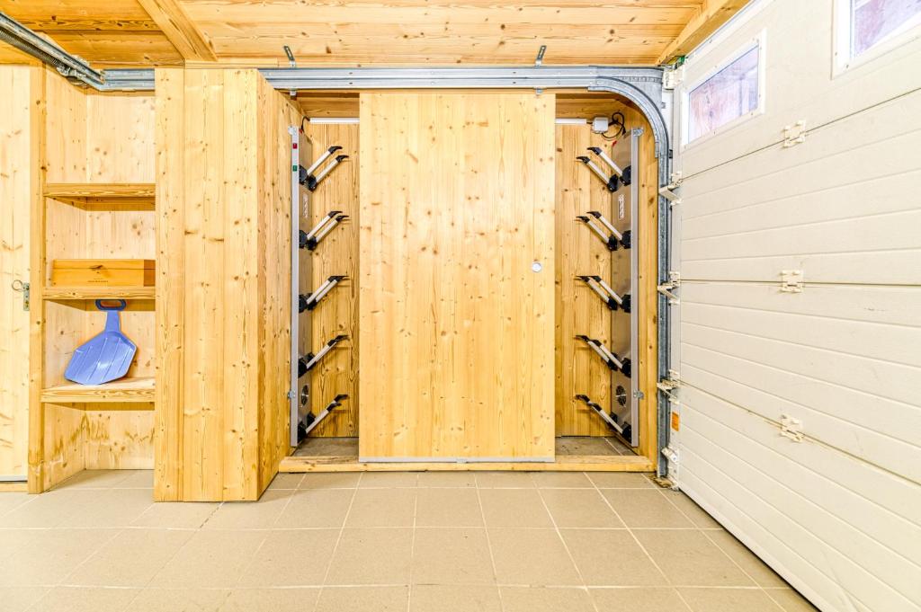a wooden garage with a door with wine racks at Alpes Sweet Home - Chalet La Biche in L&#39;Alpe-d&#39;Huez