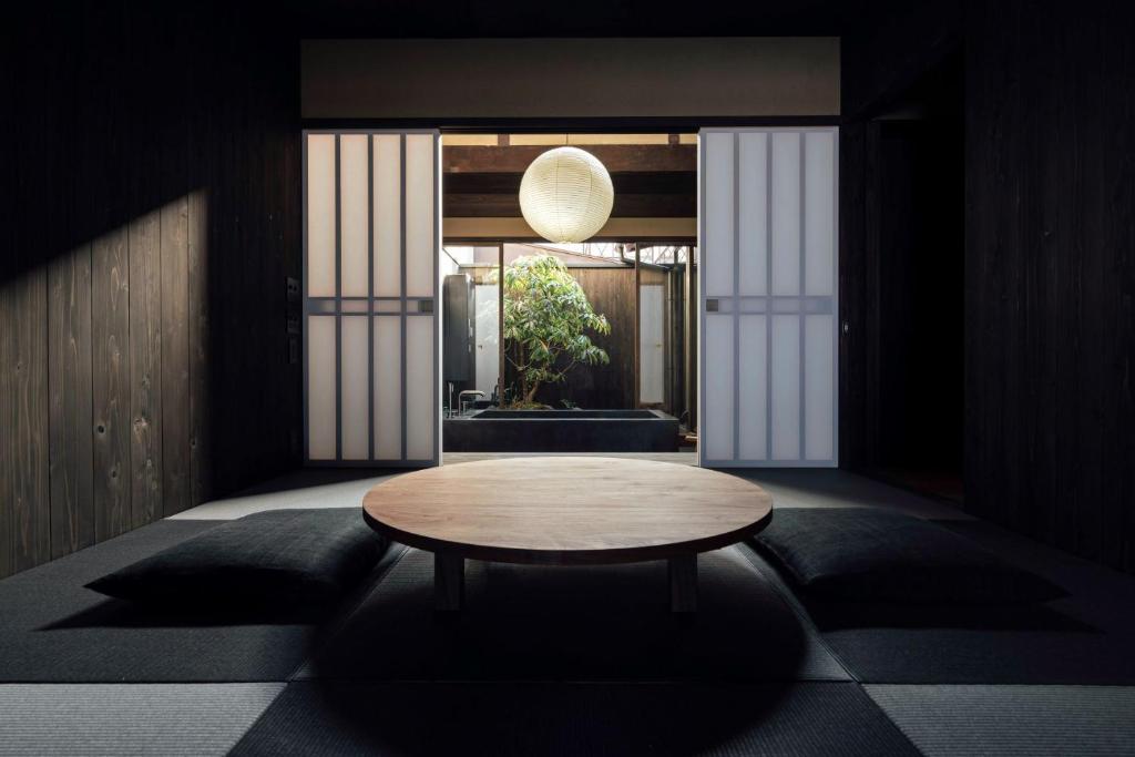 a room with a table in the middle of a room at Maana Kamo in Kyoto