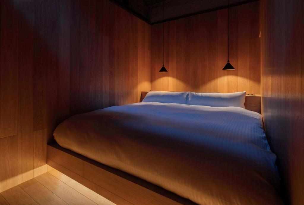 Un dormitorio con una cama grande con luces. en Maana Kamo, en Kioto