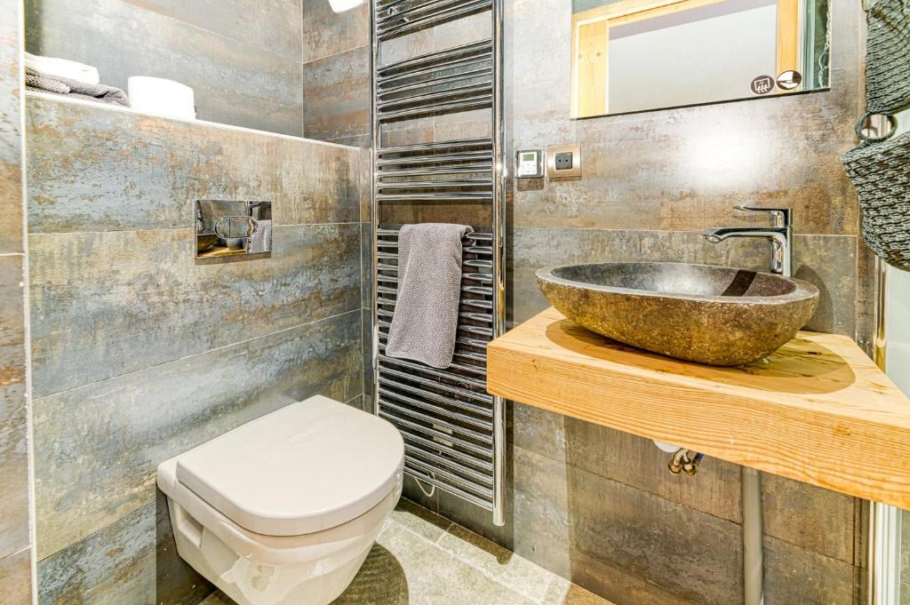 a bathroom with a sink and a toilet at Alpes Sweet Home - Chalet La Biche in L&#39;Alpe-d&#39;Huez