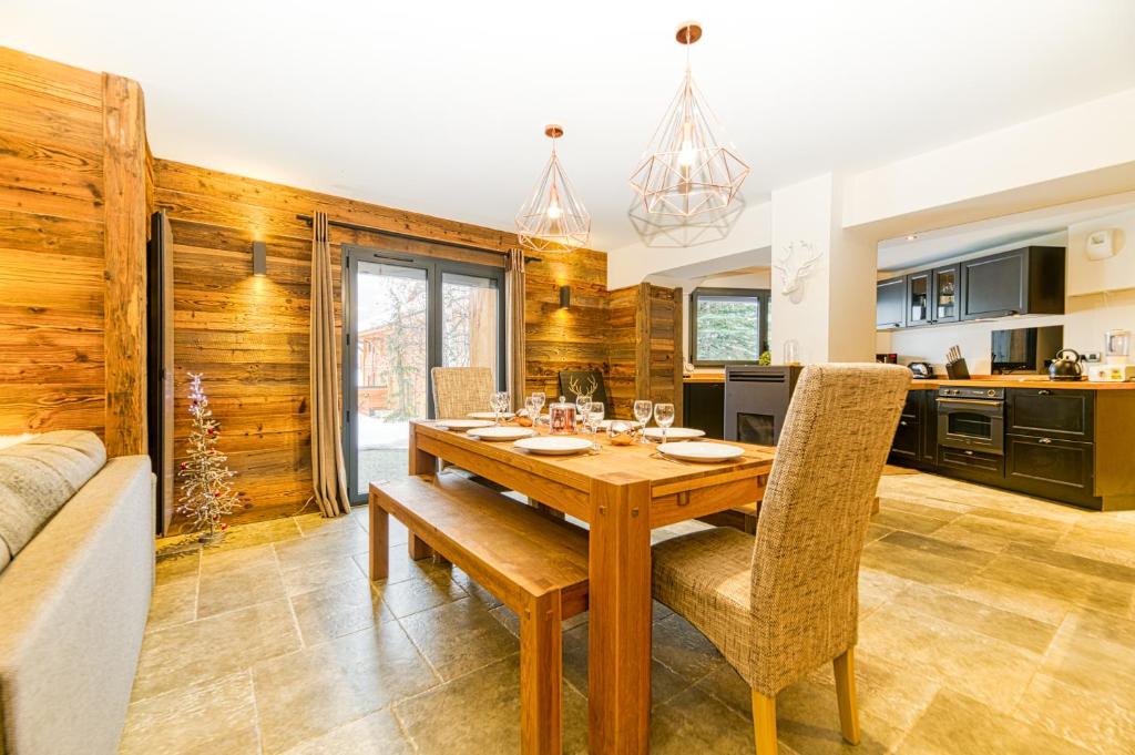 a kitchen and dining room with a table and chairs at Alpes Sweet Home - Chalet La Biche in L&#39;Alpe-d&#39;Huez