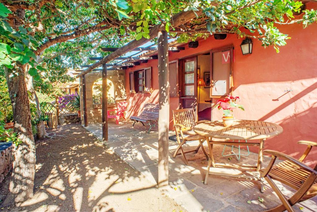 un patio con mesa y sillas bajo un árbol en Casa La Cuadra, en Telde