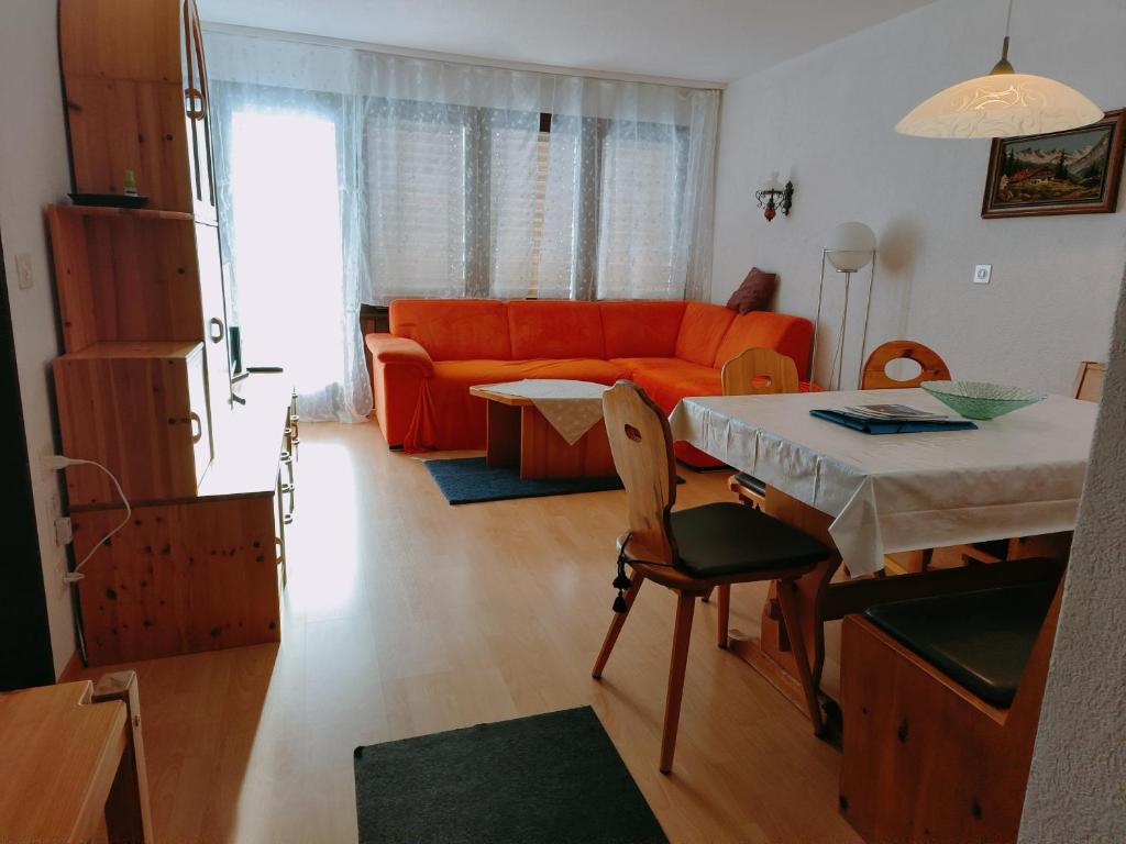 グレヘンにあるHaus Azurit Wohnung Nr.25のリビングルーム(オレンジ色のソファ、テーブル付)