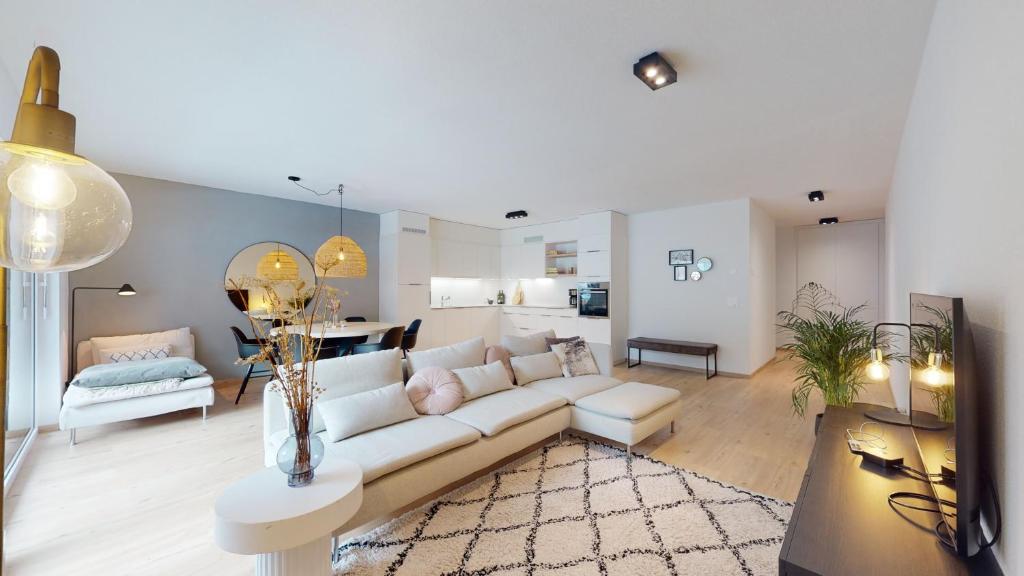 sala de estar con sofá blanco y mesa en Sublime modern family apartment of 2 bedrooms en Leukerbad