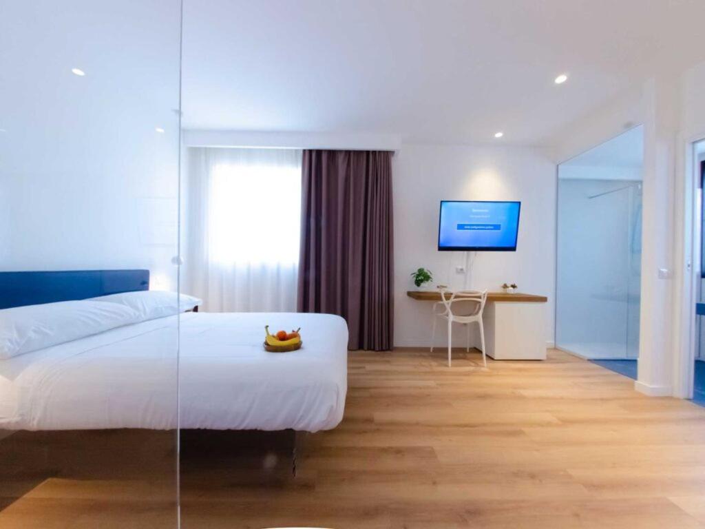 een slaapkamer met een wit bed, een tafel en een bureau bij Pascià Boutique Hotel in Ragalna