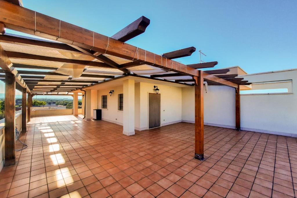 a large patio with a brick floor and wooden roof at Appartamento Corallo - MyHo Casa in Torre Canne