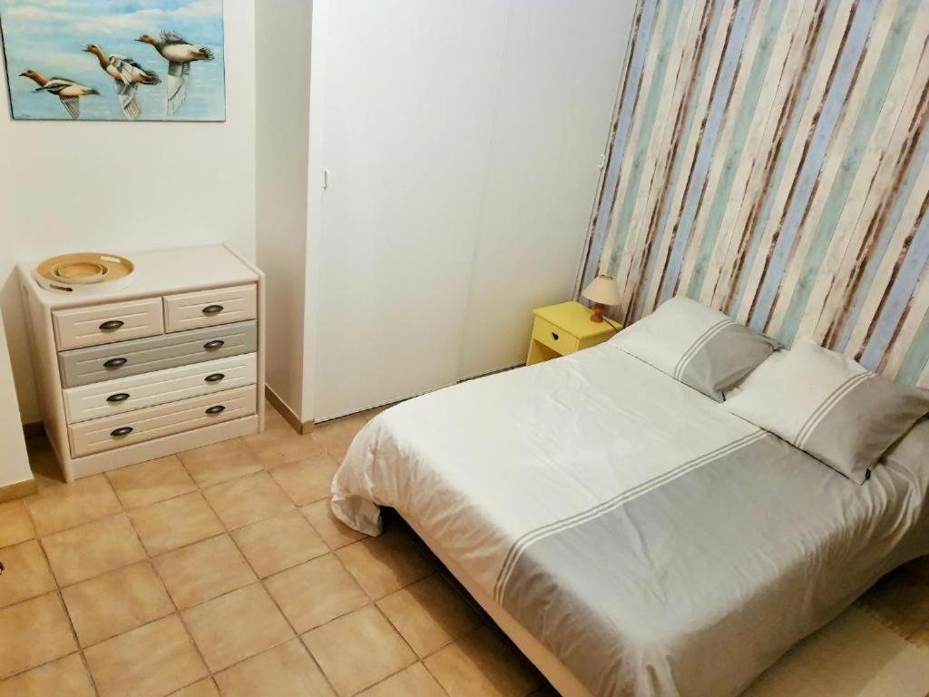 Dormitorio pequeño con cama y vestidor en Chambre spacieuse et calme en Grand-Village-Plage