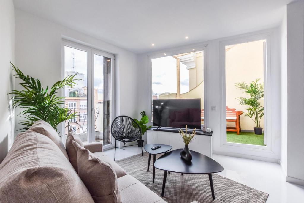 salon z kanapą i telewizorem w obiekcie Apartamento Embajadores VI w Madrycie