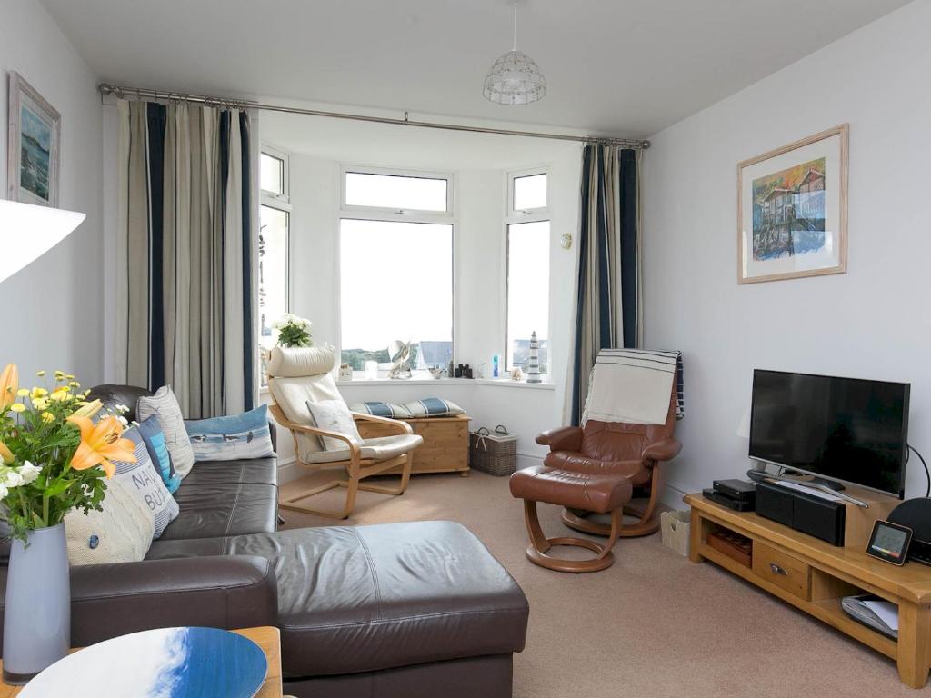 a living room with a couch and a tv at Pass the Keys Modern 2 Bedroom Apartment with stunning Sea Views in Trearddur