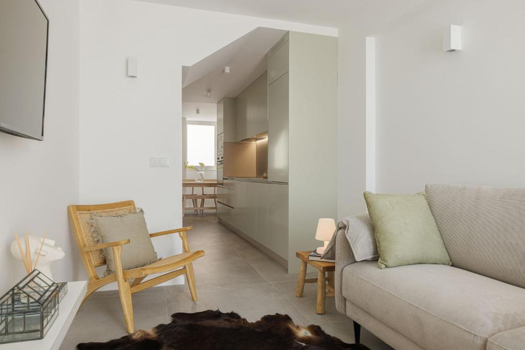uma sala de estar com um sofá e cadeiras e uma cozinha em Lapa 84-A - seafront house na Póvoa do Varzim