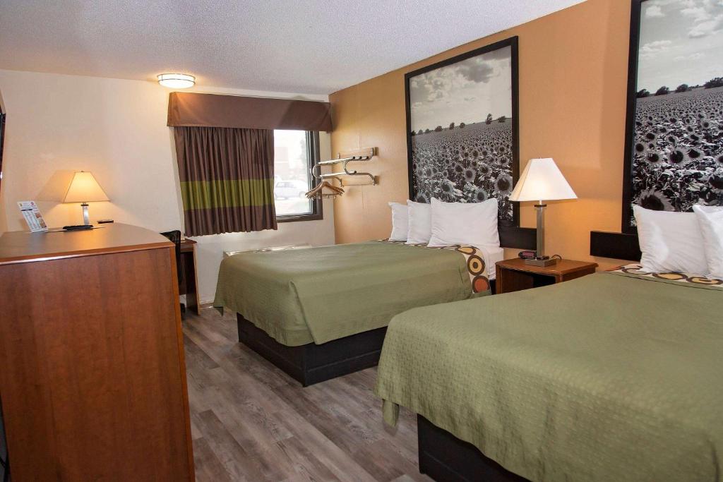 a hotel room with two beds and a television at Super 8 by Wyndham Concordia in Concordia