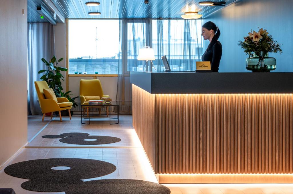 a woman standing at a counter in an office at Hotel Sparre in Porvoo