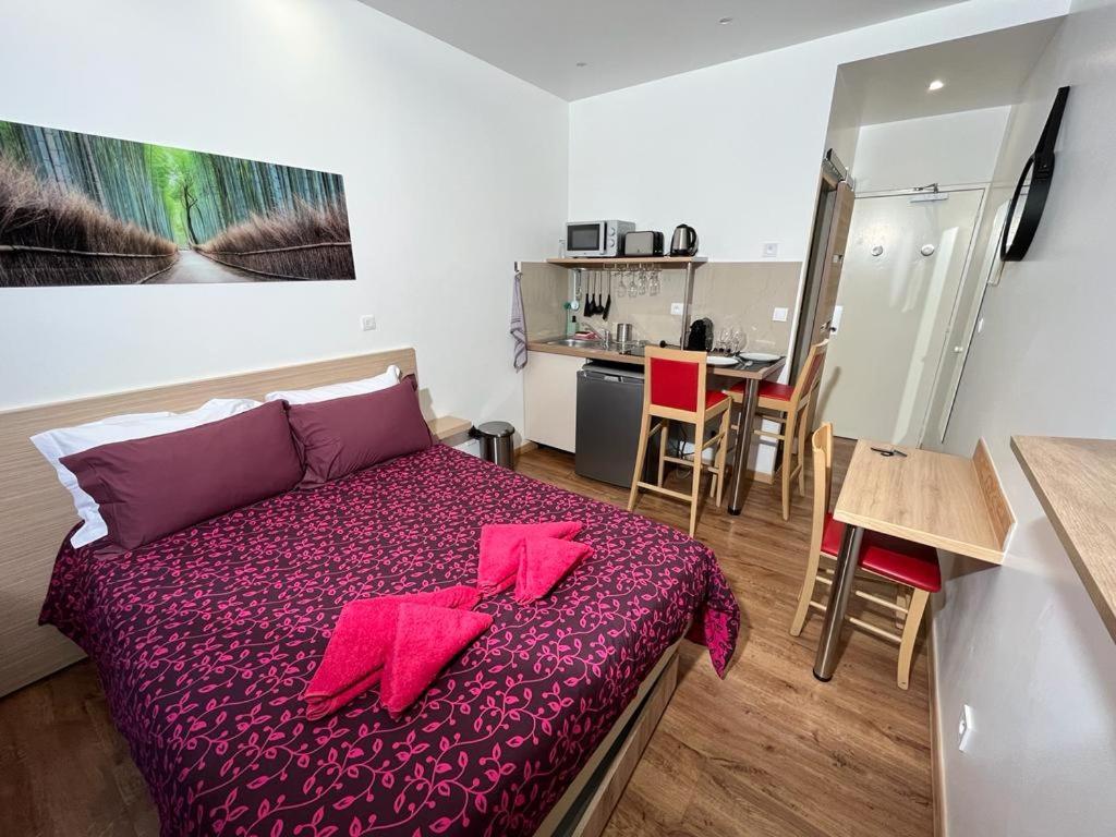 Un dormitorio con una cama con servilletas rojas. en Residence Akantha en Niza