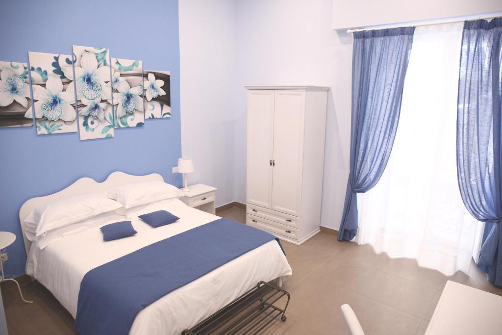 ナポリにあるラ バイア ディ パルテノペの青い壁のベッドルーム1室(ベッド1台付)