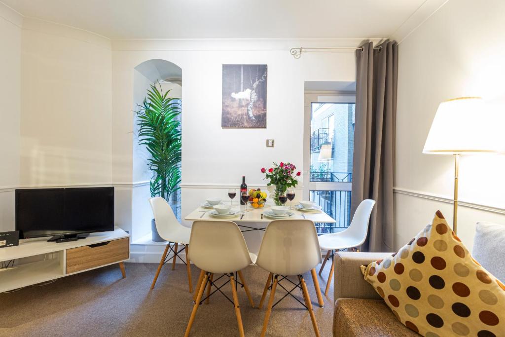 a living room with a couch and a table with chairs at Stay Thames River in London