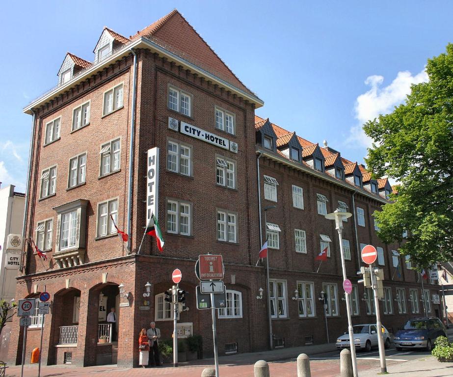 ein großes rotes Backsteingebäude mit einem Schild darauf in der Unterkunft City Hotel in Delmenhorst