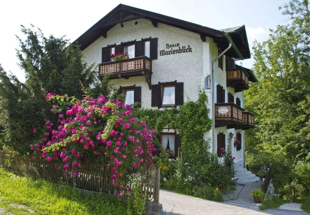 ein Gebäude mit rosa Blumen davor in der Unterkunft Ferienwohnungen Haus Marienblick in Berchtesgaden