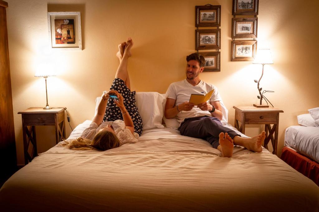 un hombre y una mujer acostados en una cama en Kau Kaleshen en El Calafate