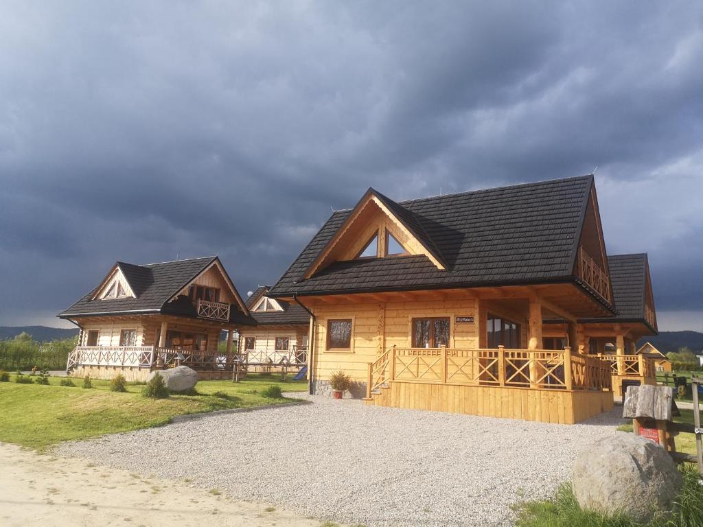 a large wooden house with a black roof at DOMEK POD LIMBAMI IV in Kluszkowce