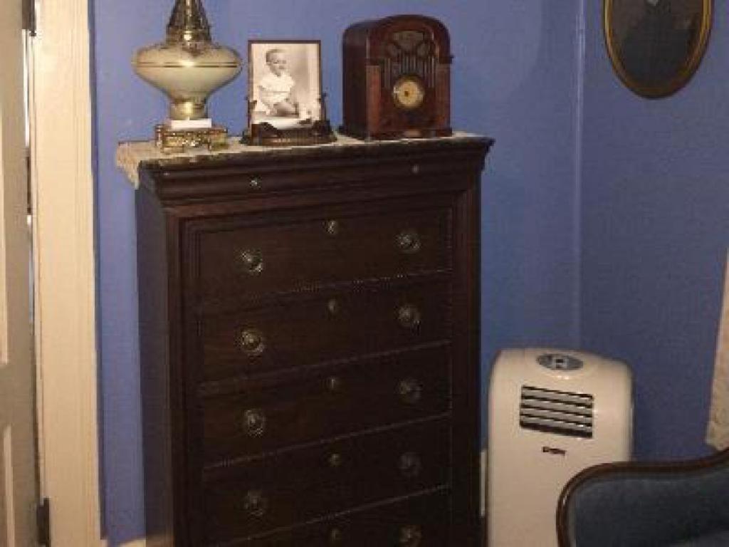 a dresser in a room with a clock and a radiator at The Jewell of Vienna in Vienna