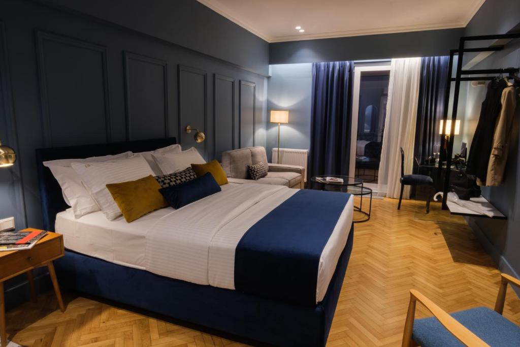 Schlafzimmer mit einem Kingsize-Bett und einem Stuhl in der Unterkunft K23 Color Suites in Athen