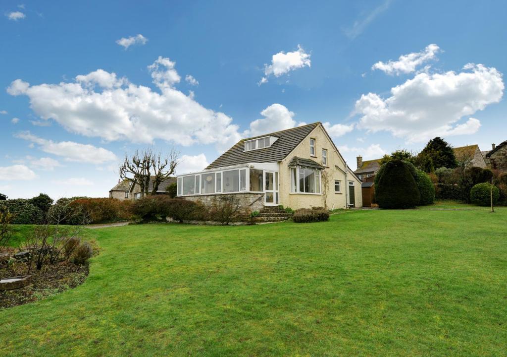a house with a large lawn in front of it at Cornerways in Worth Matravers