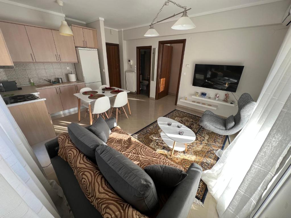 a living room with a couch and a table and a kitchen at SilverLine Comfort Apartment in Thessaloniki