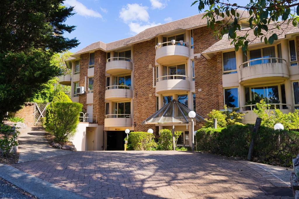 a large brick building with a driveway in front of it at Wahroonga Furnished Apartments in Hornsby