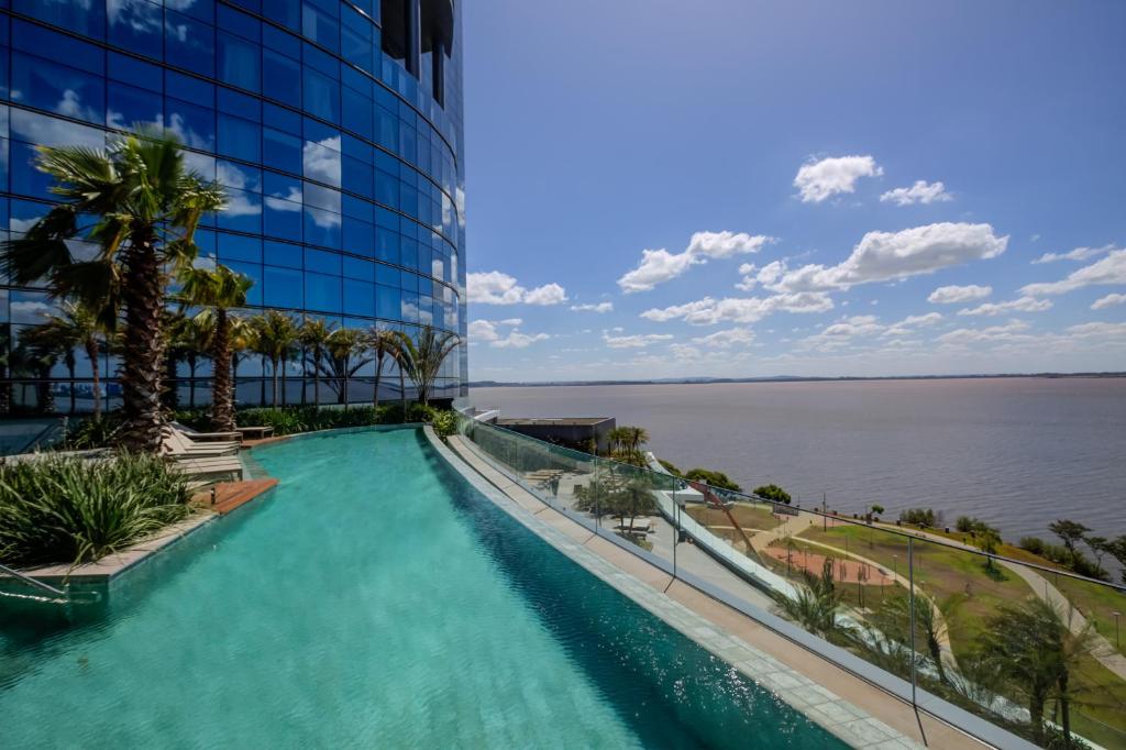 uma piscina em frente a um edifício com a água em DoubleTree by Hilton Porto Alegre em Porto Alegre