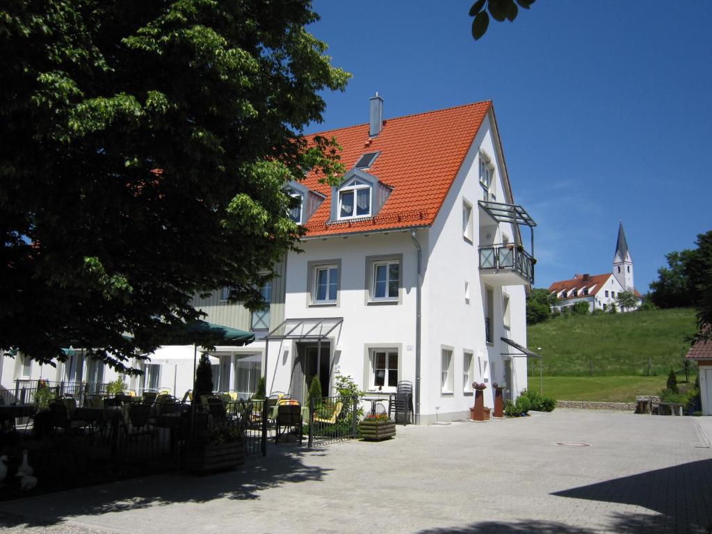 une grande maison blanche avec un toit orange dans l'établissement Gästehaus am Rastberg, à Langenbach