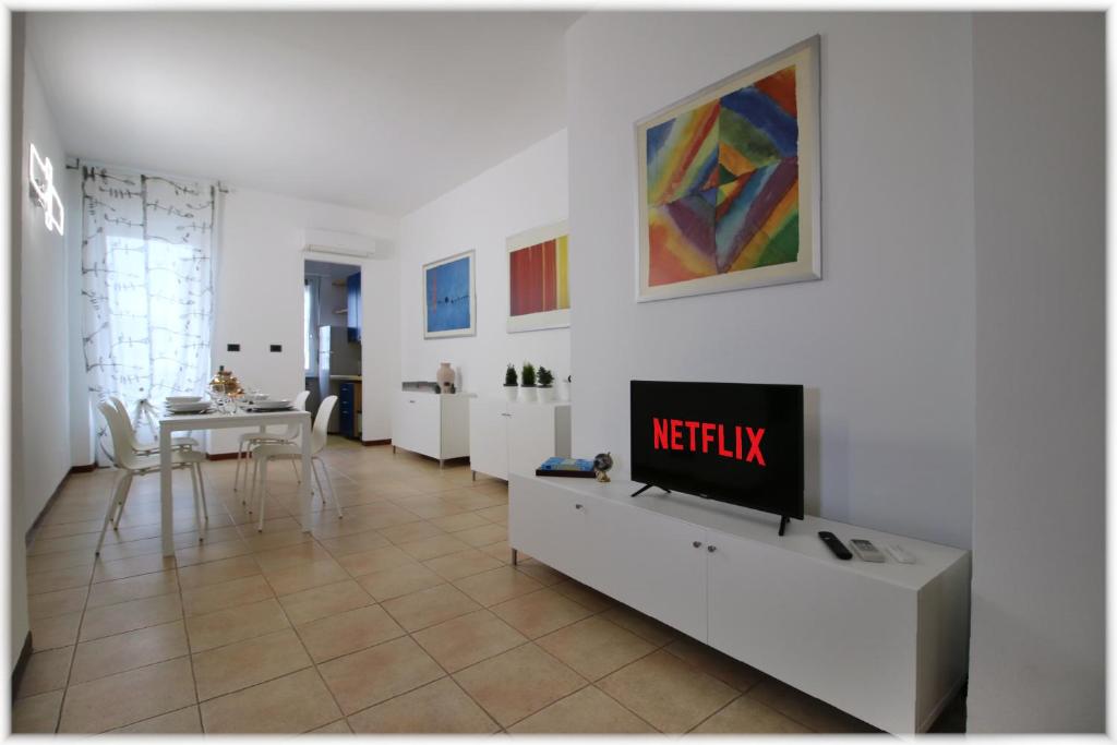 a living room with a tv on a white wall at [10 min metro] Palavela Suite in Turin
