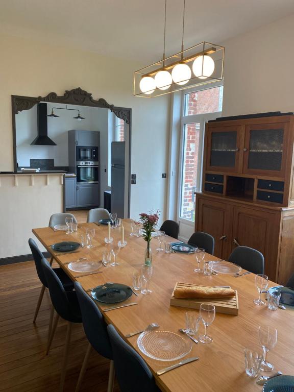 - une grande table en bois dans une chambre avec des chaises dans l'établissement Le Haut 33 : Maison bourgeoise de caractère à Laon, à Laon