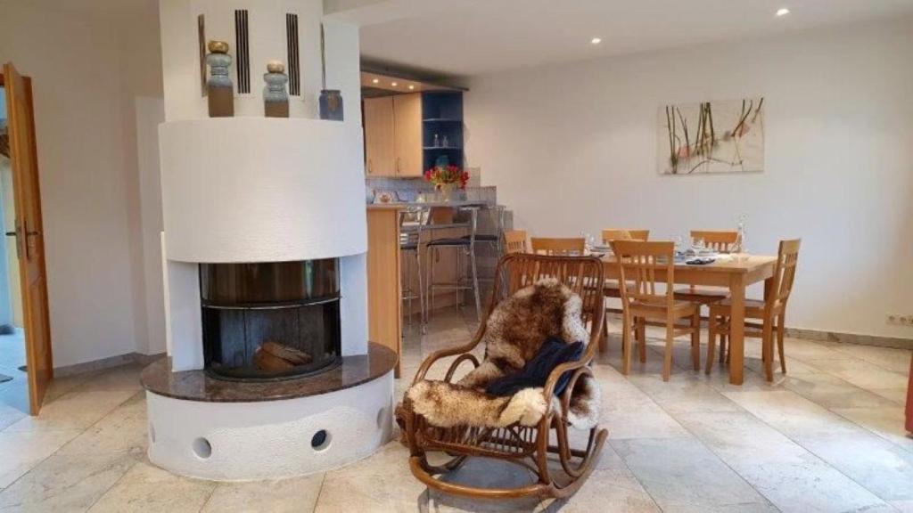 uma sala de estar com lareira e uma sala de jantar em Margerite em Mirow