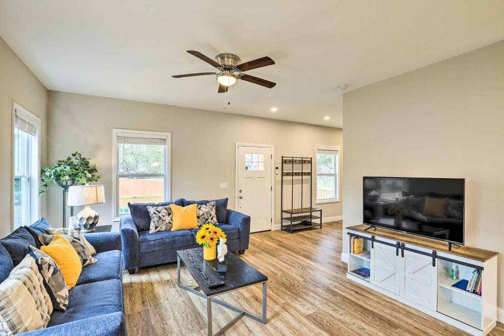 a living room with a blue couch and a flat screen tv at Contemporary Home 8 Mi to Downtown Asheville! in Asheville
