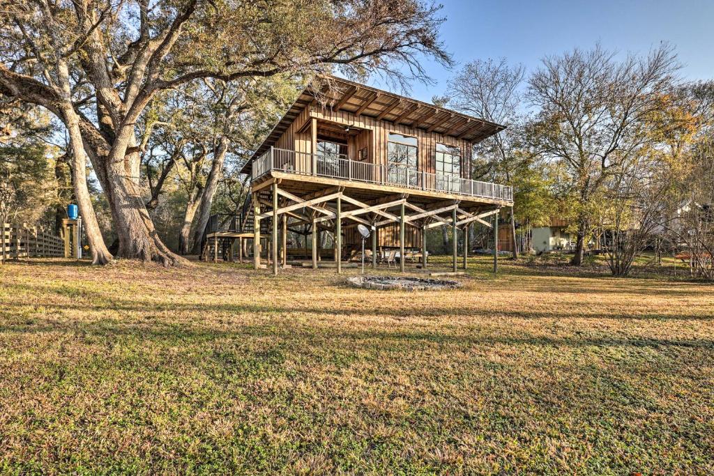 a tree house with a deck in a field at Renovated Fort White Retreat with River Access! in Fort White