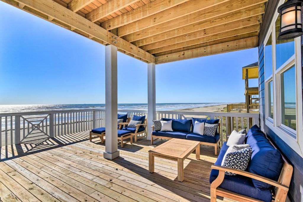una terraza con muebles azules y la playa en Freeport Beachfront Home with Deck, Ocean Views, en Freeport