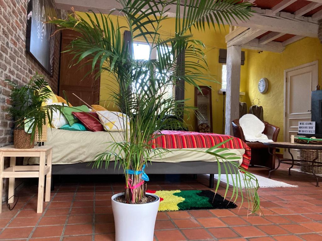 ein Schlafzimmer mit einem Bett und Pflanzen in einem Zimmer in der Unterkunft Karibu Keerbergen in Keerbergen