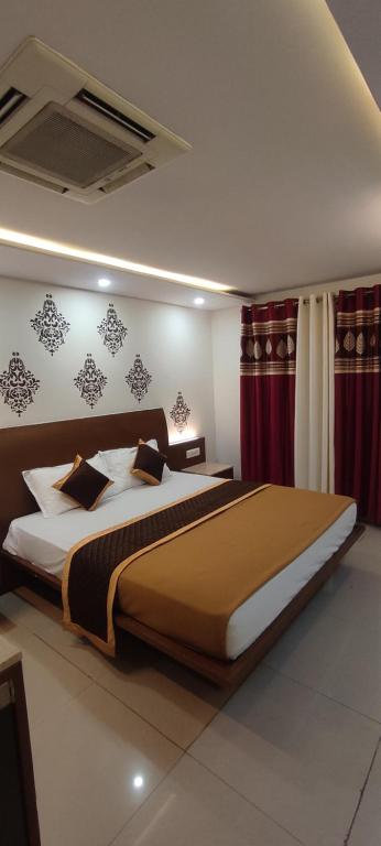 a large bed in a bedroom with red curtains at Happy Vibes Nest-studio flat in Vānivilāsa Puram