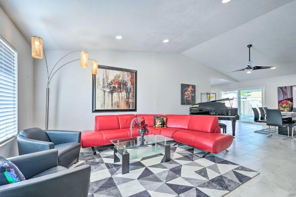 - un salon avec un canapé rouge et un piano dans l'établissement Pet-Friendly Phoenix Home with Private Pool and Grill!, à Phoenix